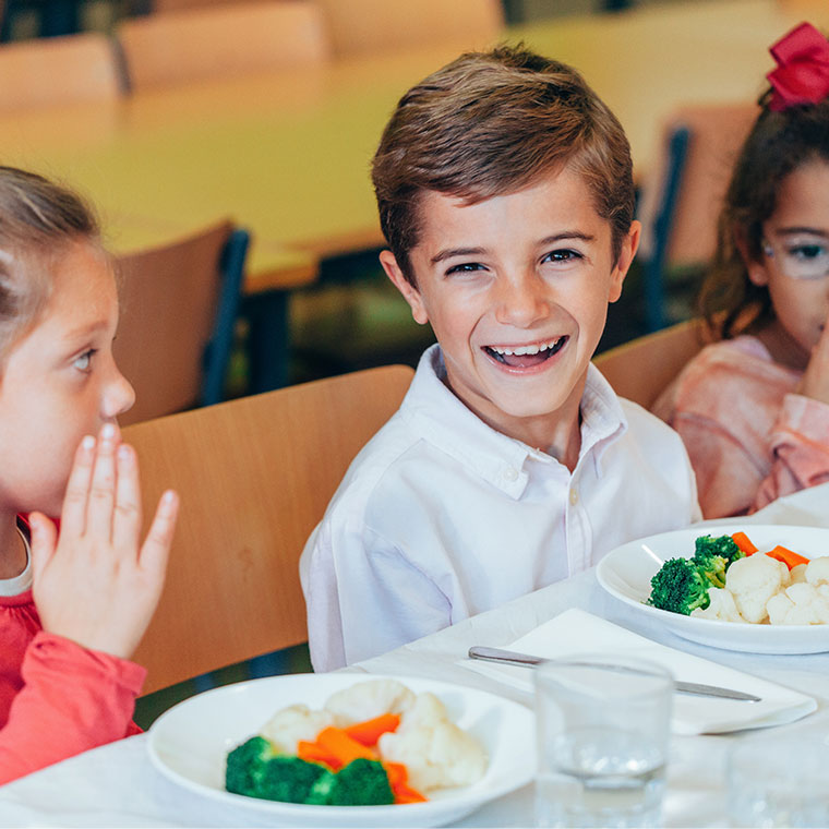 Kinder essen in der Schulkantine.