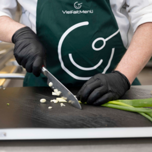 VielfaltMenü Mitarbeiter schneidet Gemüse